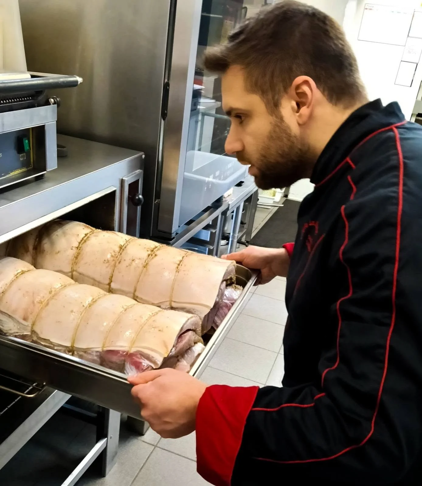 Eros enfourne la porchetta dans la cuisine d’Erofla.