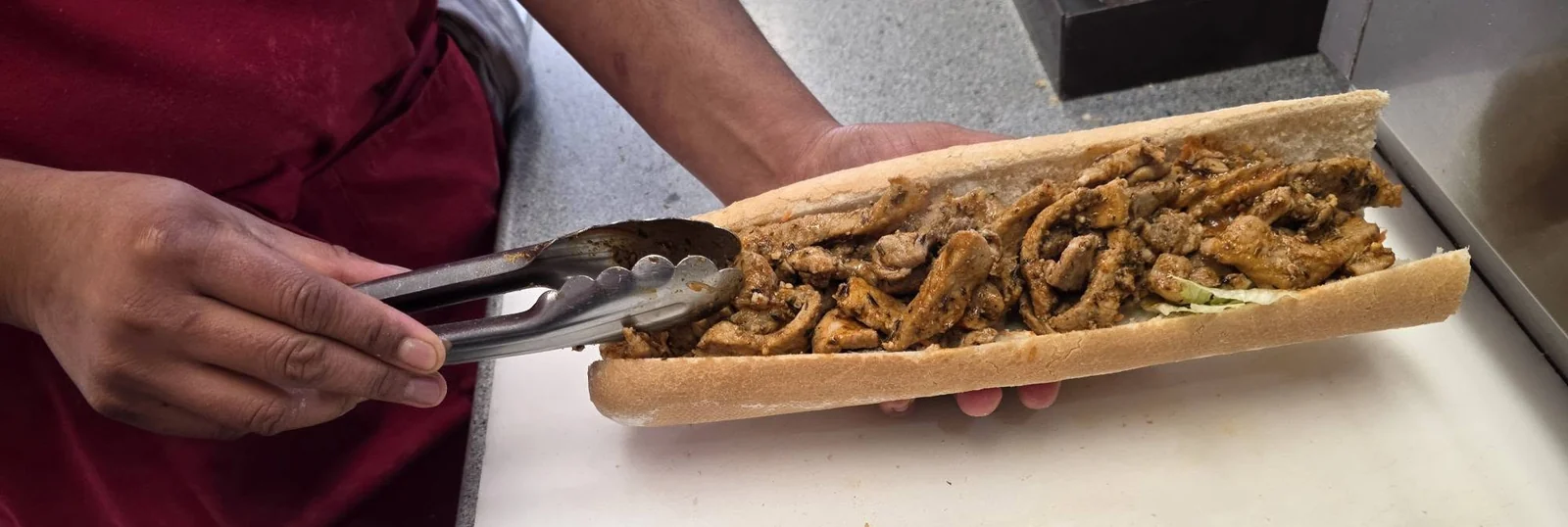 Préparation d’un sandwich chaud chez Erofla.